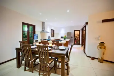 a kitchen and dining room with a table and chairs at Philana Cozy 3 BR Private Pool Villa in Seminyak