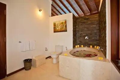 a bathroom with a bath tub and a toilet at Philana Cozy 3 BR Private Pool Villa in Seminyak