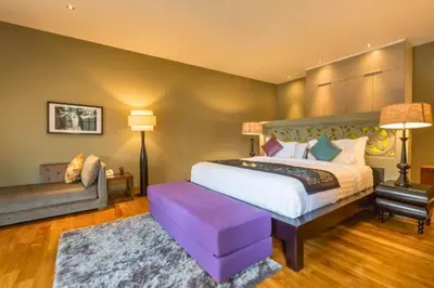 a bedroom with a king sized bed and a couch at Kalysta Spacious 4 BR Private Pool Villa in Canggu