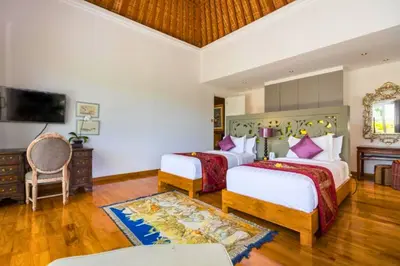 a hotel room with two beds and a television at Kalysta Spacious 4 BR Private Pool Villa in Canggu