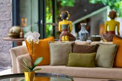 a living room with a couch with pillows and a table at Kalysta Spacious 4 BR Private Pool Villa in Canggu