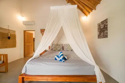 a bed with a canopy in a room at Tropical 2BR Pool Villa near Seminyak & Canggu in Kerobokan