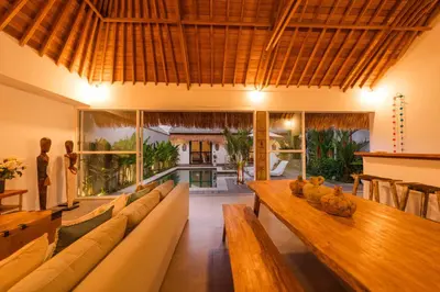a living room with a long couch and a table at Tropical 2BR Pool Villa near Seminyak & Canggu in Kerobokan