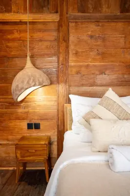 a bedroom with a bed with a wooden wall at Tuluscoliving Villa Kuta 3, 3 Bedroom & 3 Bathroom in Ngurah Rai International Airport