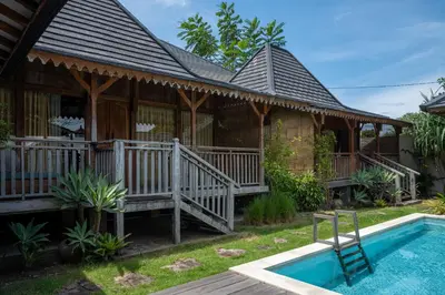 a house with a deck and a swimming pool at Tuluscoliving Villa Kuta 3, 3 Bedroom & 3 Bathroom in Ngurah Rai International Airport