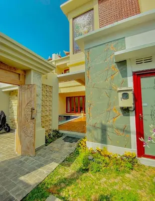 a house with a red door on the side of it at quiet and comfortable villa in sanur kauh in Sanur