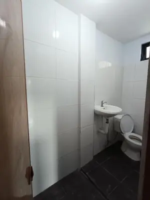 a white bathroom with a toilet and a sink at WiNHOUSE 2 in Legian