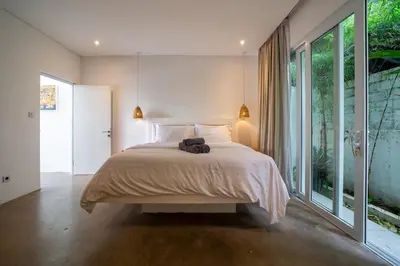 a bedroom with a large bed and a large window at Luxury 2BR Dharma Villa 5 Private Pool in Canggu in Canggu