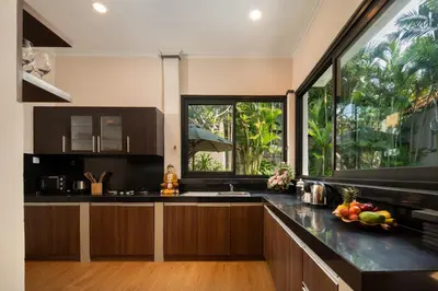 a kitchen with black counters and a large window at Red Lotus Seminyak Villa in Seminyak