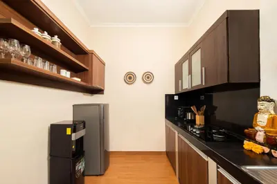 a kitchen with black counter tops and a refrigerator at Red Lotus Seminyak Villa in Seminyak