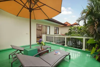 a patio with a table and chairs and an umbrella at Red Lotus Seminyak Villa in Seminyak