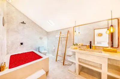 a bathroom with a red bathtub with a toilet at 3BR Villa | Seminyak Central | 450m From Beach in Seminyak