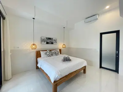 a bedroom with a bed and a mirror in it at Gede Awan Guesthouse in Kerobokan