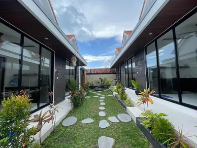 an internal courtyard of a building with a garden at Gede Awan Guesthouse in Kerobokan
