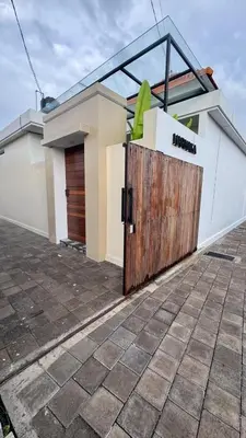 a house with a wooden gate in front of it at Villa Harmaka in Kerobokan