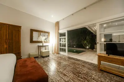 a living room with a television and a large window at Tides Seminyak in Seminyak