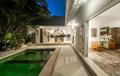 a house with a swimming pool in the middle of a yard at Tides Seminyak in Seminyak
