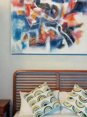 a painting above a bed with pillows on it at Villa Jovino - Jameja By Island Villa Management in Kerobokan