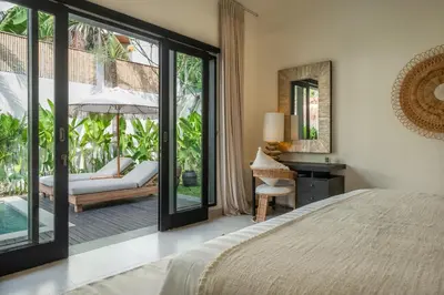 a bedroom with a bed and a desk with a mirror at Villa Lediana - 3BR Private pool in Canggu