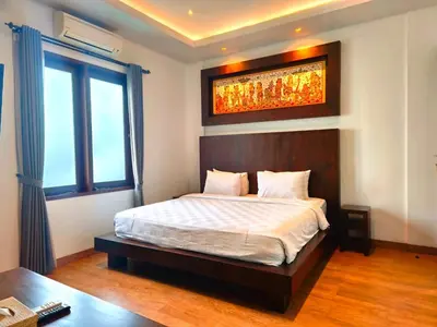 a bedroom with a bed and a large window at Tahoma Villas Nakula by ABM in Legian