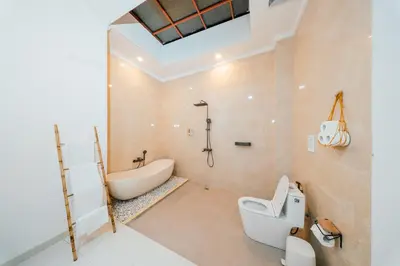 a bathroom with a tub and a toilet and a sink at Villa Tyaga in Kerobokan