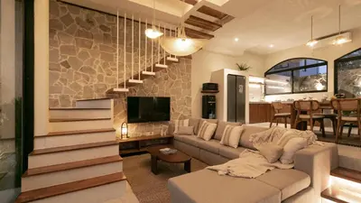 a living room with a couch and a staircase at Casa Amani 3BR Mediterranean w Pool Near Seminyak in Kerobokan