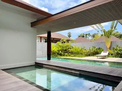 an external view of a house with a swimming pool at Villa Daun Emas in Jimbaran