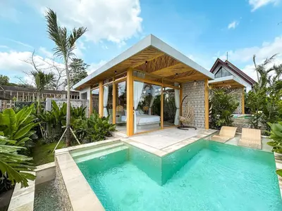 a villa with a swimming pool and a house at Desa Hut - Tropical Haven with Ricefield View near Seminyak in Kerobokan