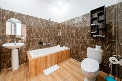 a bathroom with a tub and a toilet and a sink at Mertasari Beach Villa Sanur - 3 BR in Sanur