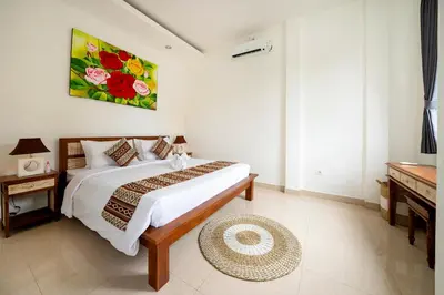 a bedroom with a bed and a painting on the wall at Mertasari Beach Villa Sanur - 3 BR in Sanur