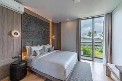 a bedroom with a large white bed and a large window at Akar & Daun - NEW! 8BR Villa Haven, Near Berawa Beach! in Canggu