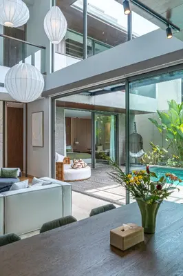 an open living room with a dining table in a house at Akar & Daun - NEW! 8BR Villa Haven, Near Berawa Beach! in Canggu