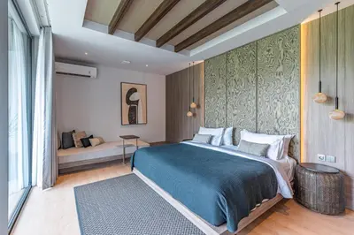 a bedroom with a large bed and a couch at Akar & Daun - NEW! 8BR Villa Haven, Near Berawa Beach! in Canggu