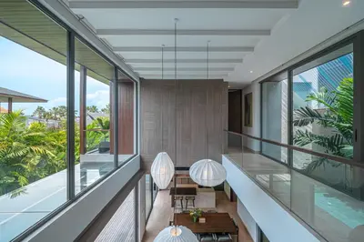 an indoor balcony with glass walls and floor to ceiling windows at Akar & Daun - NEW! 8BR Villa Haven, Near Berawa Beach! in Canggu