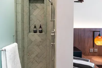 a bathroom with a shower with two bottles of wine at Baliris Home Boutique Legian in Seminyak