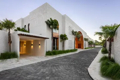 a house with palm trees on a street at Nila Villa Berawa Canggu in Canggu
