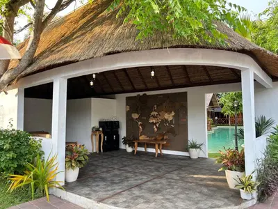 a pavilion with a thatched roof and a table at Cozy Lagoon Bungalows & Pool in Nusa Dua