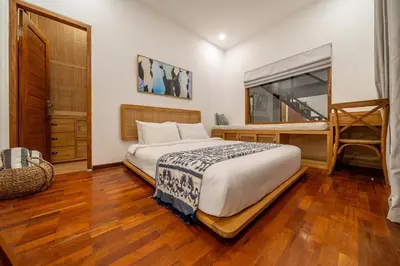 a bedroom with a bed and a wooden floor at 2BR Private tropical villas in Jimbaran in Jimbaran