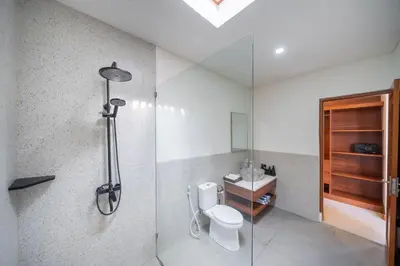 a bathroom with a shower and a toilet and a sink at Modern 2BR Umalas Villa with Private Pool & Garden in Kerobokan
