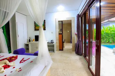 a bedroom with a bed and a room with a pool at 1 Bed Room Villa in Kuta Central in Kuta