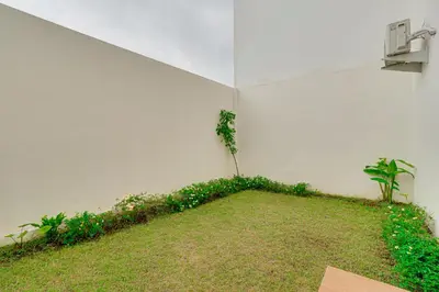 a white room with a plant in the corner of it at Cozy 2BR Villa Taman Seminyak Suite 05 in Seminyak Bali in Seminyak