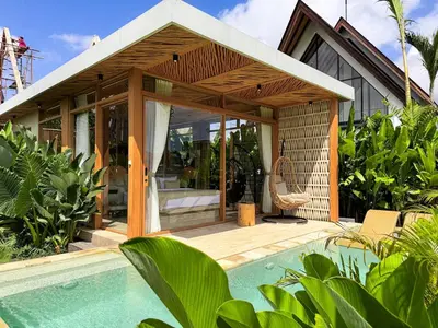a house with a swimming pool next to a house at Desa Hut - Serene Tropical Hideaway Rice Fields near Seminyak in Kerobokan