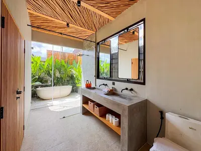 a bathroom with a tub and a sink and a mirror at Desa Hut - Serene Tropical Hideaway Rice Fields near Seminyak in Kerobokan