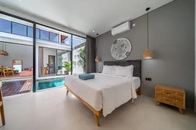 a bedroom with a large bed and a swimming pool at Harmony A29-Peaceful 1BR Retreat in Seminyak