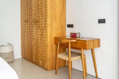 a wooden desk with a chair next to a bed at Harmony A29-Peaceful 1BR Retreat in Seminyak