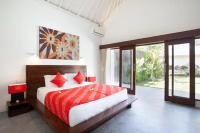 a bedroom with a large bed with red pillows at Villa Alma in Legian