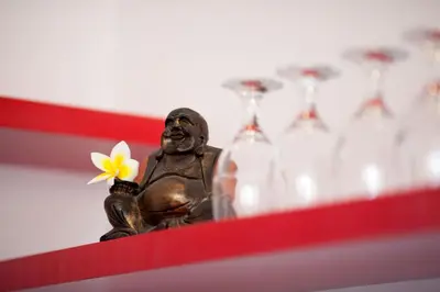 a statue of a man holding a flower and wine glasses at Villa Alma in Legian
