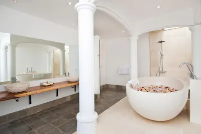 a bathroom with a large tub and a mirror at Villa Amalia Walk To Legian Beach in Legian
