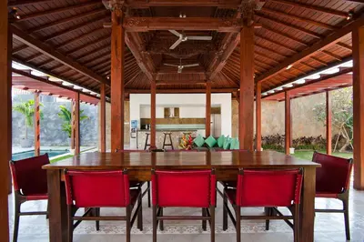 a dining room with a large wooden table and chairs at Villa Amalia Walk To Legian Beach in Legian
