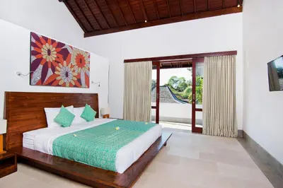 a bedroom with a large bed and a large window at Villa Amalia Walk To Legian Beach in Legian